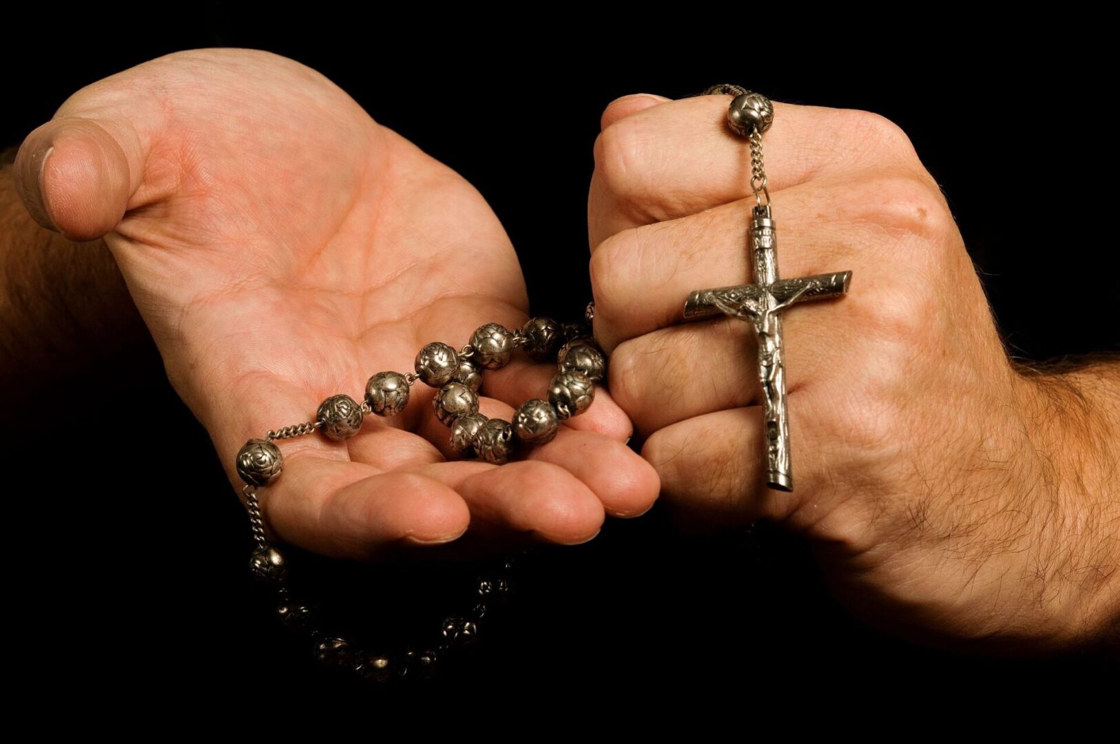 A person holding a rosary in their hands.